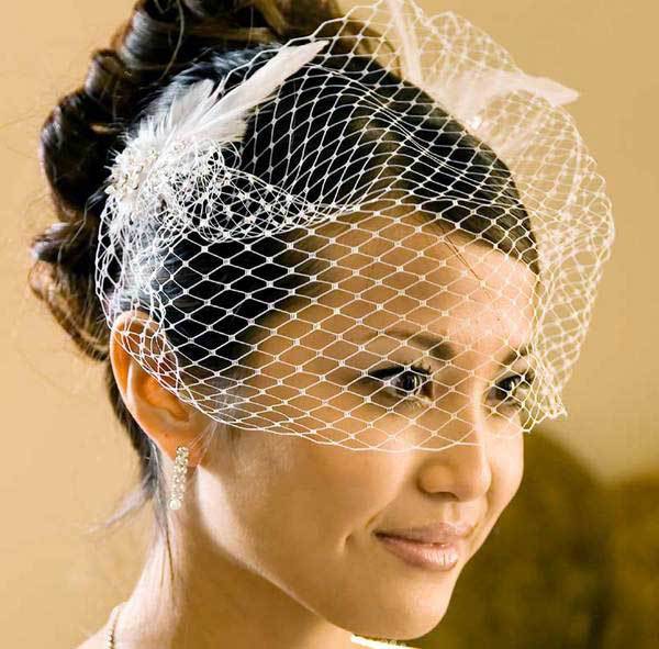 Modern and chic White or Ivory bridal feather fascinator features veil nose-length birdcage veil